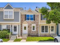 Charming townhome featuring a stone facade, well-maintained lawn, and inviting front entrance at 1240 S Idalia St, Aurora, CO 80017