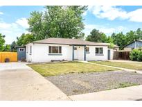 Charming exterior view of a renovated home with a fresh white paint job and landscaped front yard at 6500 W 32Nd Ave, Wheat Ridge, CO 80033