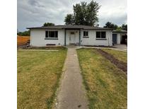 Charming single-story home featuring a well-manicured front lawn, a concrete walkway, and a freshly painted exterior at 6500 W 32Nd Ave, Wheat Ridge, CO 80033