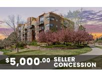 Beautiful condo building with well-maintained landscaping, mature trees, and a walking path at 9019 E Panorama Cir # D204, Englewood, CO 80112