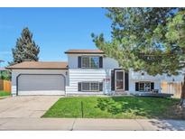 Split level home featuring a two car garage, front lawn and mature trees at 9135 W Maplewood Ave, Littleton, CO 80123