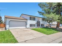 Split level home featuring a two car garage, front lawn and mature trees at 9135 W Maplewood Ave, Littleton, CO 80123
