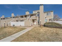 Charming townhome with neutral siding, white picket fence and inviting entryway on a sunny day at 8095 E Colorado Ave # 5, Denver, CO 80231