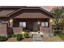 Charming front porch featuring stone pillars, decorative lighting, and a welcoming entrance at 15501 E 112Th Ave # 20C, Commerce City, CO 80022