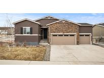 Charming home featuring a stone facade, a two-car garage, and neat landscaping at 5221 Trails Edge Ln, Castle Rock, CO 80104