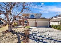 Charming two-story home with brick and siding, a three-car garage, and a landscaped front yard at 8941 Tuscany Ln, Highlands Ranch, CO 80130