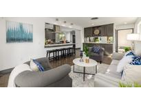 Open-concept living room featuring modern furnishings and an eat-in kitchen with a bar at 6490 E Dakota Ave, Denver, CO 80224