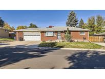 Charming single-story brick home with a well-manicured lawn and attached garage at 3359 W Layton Ave, Englewood, CO 80110
