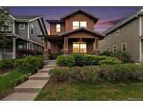Charming two-story home featuring a welcoming front porch, landscaped yard, and a beautiful sunset backdrop at 5434 N Xenia St, Denver, CO 80238