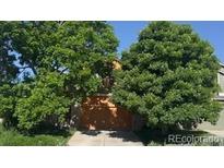 Exterior view of the property with mature trees in front of a home with a two-car garage and blue sky at 4372 E Andover Ave, Castle Rock, CO 80104