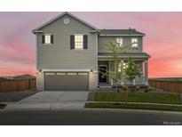 Charming two-story home with a well-manicured lawn and an attached two-car garage at 17424 E 90Th Pl, Commerce City, CO 80022
