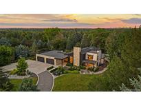 Stunning modern home featuring stone accents, a spacious driveway, and lush landscaping at sunset at 5160 S Franklin St, Greenwood Village, CO 80121