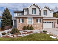 Charming two-story home with stone accents, a well-manicured lawn, and an attached two-car garage at 2677 Pemberly Ave, Highlands Ranch, CO 80126