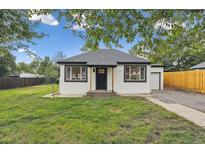 Charming single-story home featuring a well-maintained lawn, black trim, and inviting curb appeal at 11842 W 14Th Ave, Lakewood, CO 80401