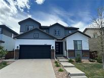 Beautiful two-story home featuring a modern color scheme, a two-car garage, and landscaped front yard at 10934 Touchstone Loop, Parker, CO 80134