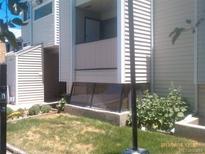 A townhouse backyard featuring a small lawn and a below ground window to the basement at 10762 E Exposition Ave. Ave # 137, Aurora, CO 80012