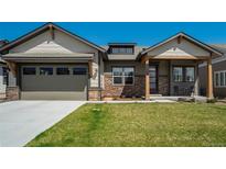 Charming home with a stone-accented facade, covered porch, and well-manicured lawn at 16277 Talons Bluff Ln, Monument, CO 80132