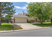 Charming home with a two-car garage, driveway, and mature trees under a sunny sky at 1245 Ceres Dr, Lafayette, CO 80026