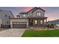 Beautiful two-story home featuring a covered porch with stone accents and a two-car garage at 11261 Moonshimmer St, Littleton, CO 80125