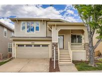 Charming two-story home with a welcoming front porch, stone accents, attached garage, and landscaped front yard at 10626 Cherrybrook Cir, Highlands Ranch, CO 80126
