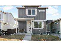 Charming two-story home featuring a covered front porch and modern gray siding, enhancing its curb appeal at 1103 Spartan Ave, Berthoud, CO 80513