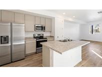 Bright kitchen featuring stainless steel appliances, granite counters and light wood flooring at 23527 E 5Th Pl, Aurora, CO 80018