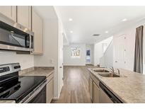 Bright kitchen features stainless steel appliances, granite countertops, and seamless flow to dining and living spaces at 23527 E 5Th Pl, Aurora, CO 80018