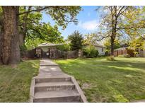 Charming home with a well-maintained lawn, mature trees, and a welcoming walkway, creating inviting curb appeal at 4567 Grove St, Denver, CO 80211