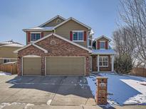 Charming two-story home with a two car garage, brick accents, and colorful red window shutters at 13517 Clayton Ct, Thornton, CO 80241