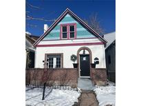 Charming home featuring a unique colorful roof, brick accents, and inviting front entrance. The property is well-maintained and welcoming at 69 W Cedar Ave, Denver, CO 80223