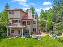 Spacious home featuring a large balcony, a patio, and well-manicured landscaping, creating an inviting outdoor living space at 2398 Bitterroot Ln, Golden, CO 80401