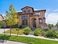 Charming two-story home featuring a stone facade, tiled roof, and professionally landscaped front yard at 2256 S Isabell Ct, Lakewood, CO 80228