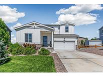 Charming two-story home featuring a well-maintained lawn and a welcoming front porch with a two car garage at 42891 Hawktree Cir, Elizabeth, CO 80107
