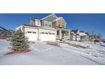 Two-story house with stone and siding, three-car garage, and snowy front yard at 1143 Williams Loop, Elizabeth, CO 80107