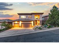 Stunning two-story home with a three-car garage, landscaped yard, and balcony showcasing an amazing sunset at 6874 Raspberry Run, Littleton, CO 80125
