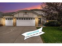Charming home features a three car garage, brick accents, and a well-manicured lawn at 22778 E Alamo Ln, Aurora, CO 80015