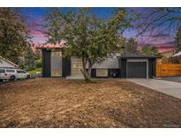 Charming split-level home showcasing a black and white exterior, attached garage, and front yard at 11172 W Exposition Dr, Denver, CO 80226