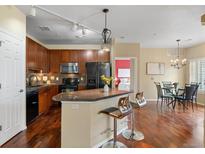 Modern kitchen with wooden cabinets, granite countertops, and stainless steel appliances at 2662 S Cathay Way # 112, Aurora, CO 80013