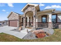 Charming home featuring a stone archway entry, beautiful stone accents and a professionally landscaped yard at 156 Chapel Hill Cir, Brighton, CO 80601