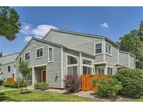Charming townhome exterior with mature landscaping, a quaint fence, and a pop of color from the front door at 5150 Buckingham Rd, Boulder, CO 80301