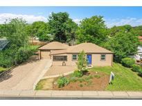 Charming single-story home with blue door, inviting landscaping and a well-maintained front yard at 485 S Pierson St, Lakewood, CO 80226