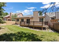 Charming backyard view featuring a well-kept lawn and a wooden deck perfect for outdoor living at 14139 W Warren Dr, Lakewood, CO 80228