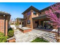 Inviting backyard with a patio, hot tub, blooming tree and well-manicured lawn, perfect for outdoor entertaining at 1131 S York St, Denver, CO 80210