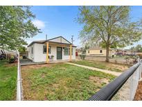 Charming home with a freshly painted exterior and a cozy front porch and fenced yard at 6980 Niagara St, Commerce City, CO 80022