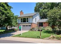 Charming two-story home featuring a brick facade, lush landscaping, and a well-maintained lawn at 12651 E Bates Cir, Aurora, CO 80014