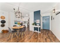 Charming dining area featuring modern lighting, wood floors, and a stylish entrance with a blue door at 7020 E Girard Ave # 209, Denver, CO 80224