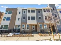 Contemporary townhome with mixed brick and gray siding, complemented by a landscaped front yard with a walkway at 14261 Currant St, Broomfield, CO 80020