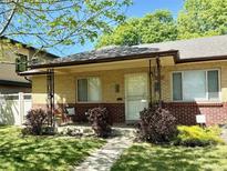 Charming brick home featuring a well-manicured lawn and inviting covered front porch perfect for relaxing at 2633 Quitman St, Denver, CO 80212