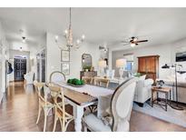 Bright dining room features a farmhouse table and chandelier, adjacent to living area at 20727 Park Hollow Dr, Parker, CO 80138