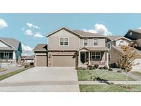 Charming two-story home features a well-manicured lawn, large driveway, and an inviting front porch at 20727 Park Hollow Dr, Parker, CO 80138